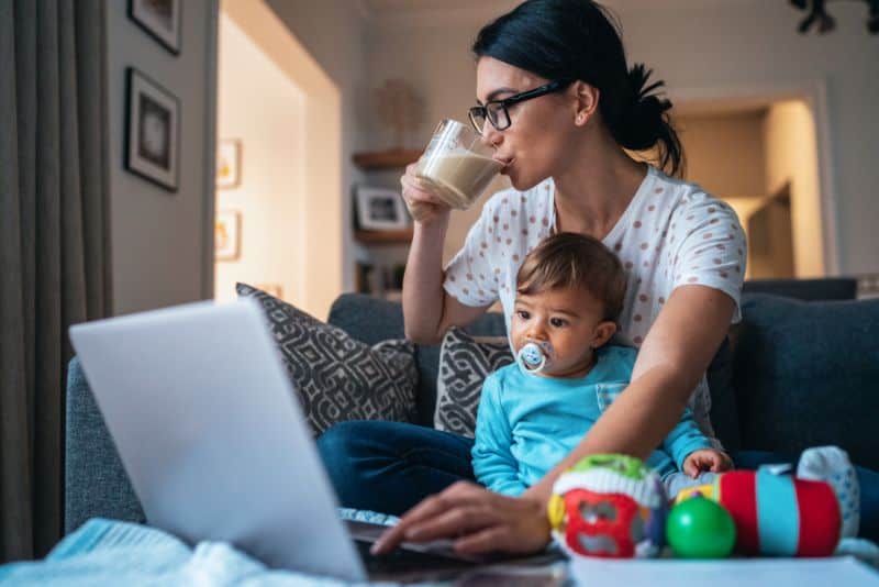 Mom on laptop with child.