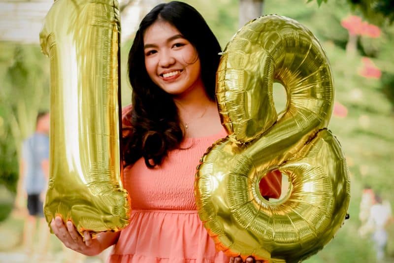 girl with 18th birthday balloons.