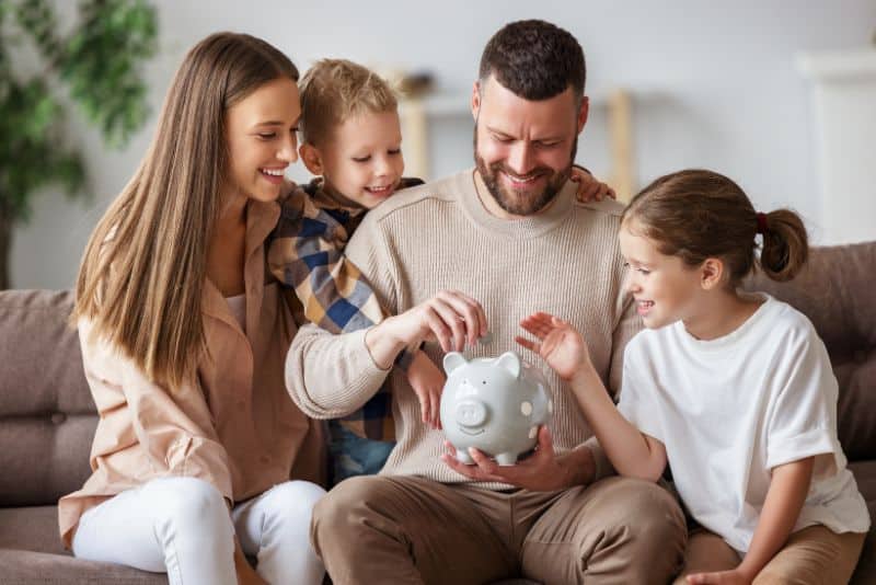 Family saving money in a piggy bank.