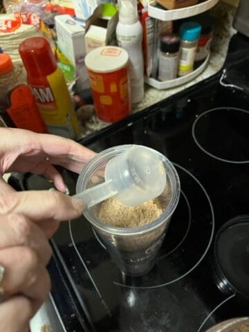Placing protein powder in a cup.