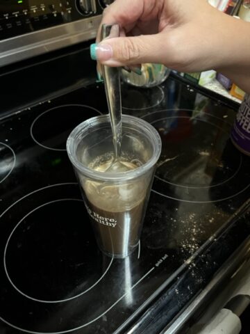 Stirring protein powder in a cup.