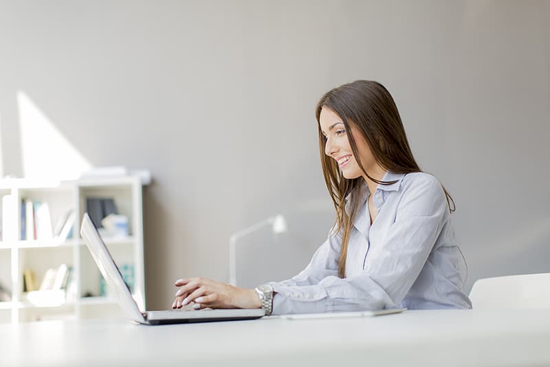 Woman at computer working and finding the best web hosting.