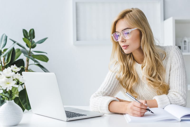 Woman on a laptop looking for the best web hosting.