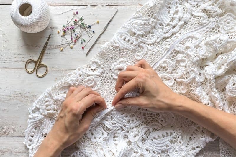 bride sewing zipper in her wedding dress