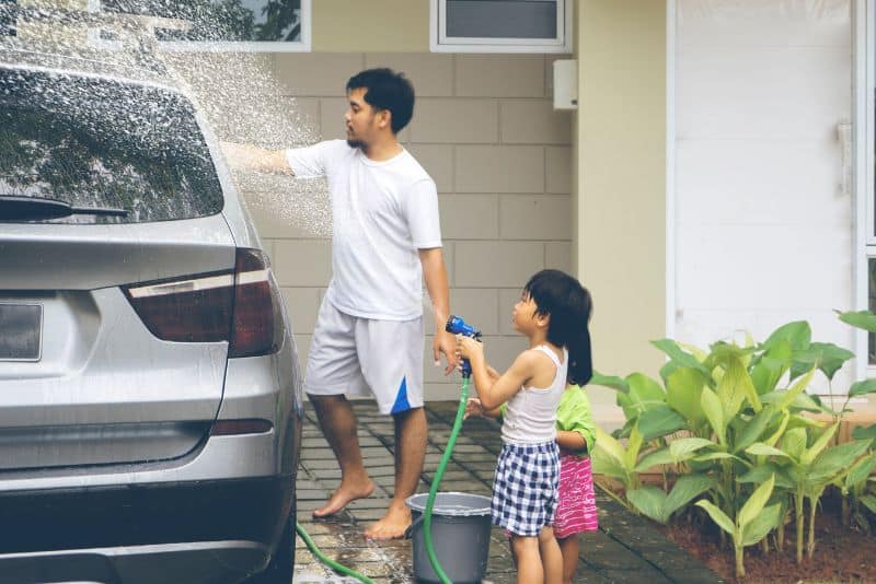 Kid washing their dad's car.