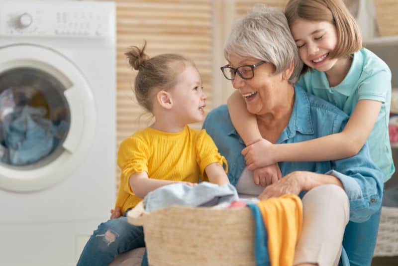 Kids doing laundry with grandma.