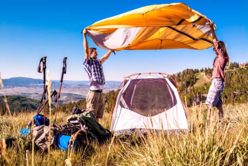Family pitching their tent to camp.