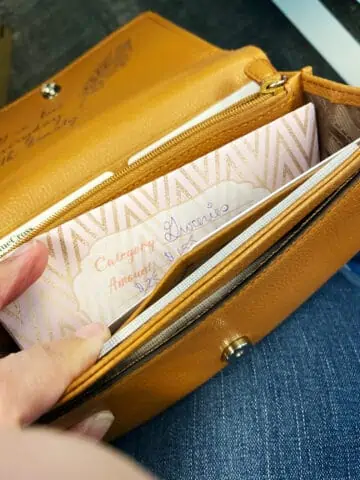 Cash envelopes will fit in most wallets and pocketbooks, like this yellow wallet with a cash envelope ready to go.