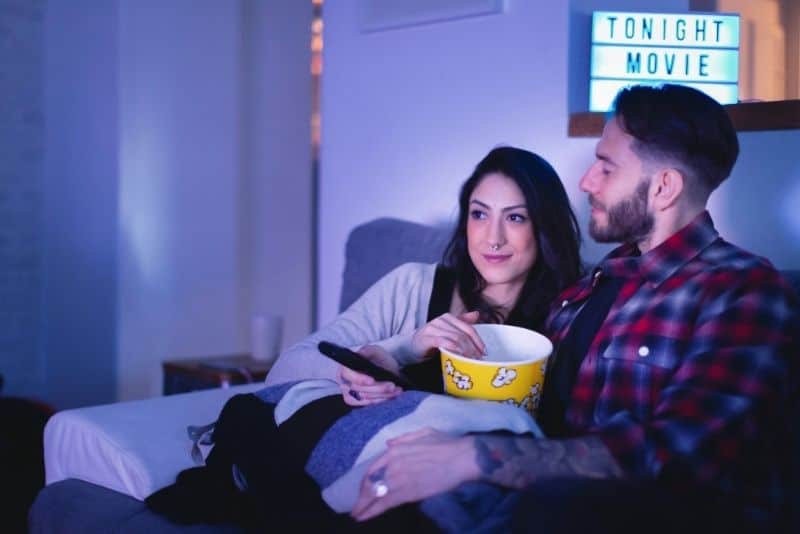 Movie watching couple that's eating popcorn and enjoying their movie.