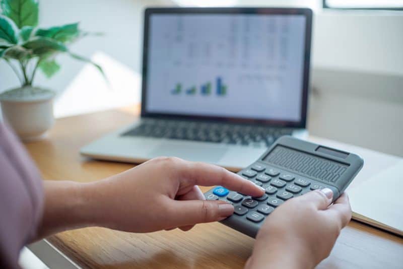 Woman using calculator to determine expenses.