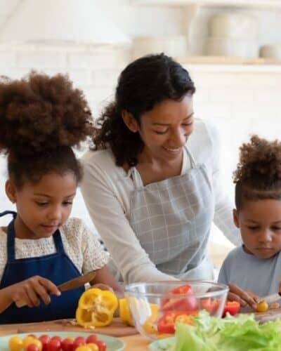 Mom cooking at home with her kids to save money.