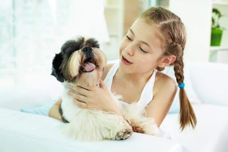 Kid holding a cute dog.