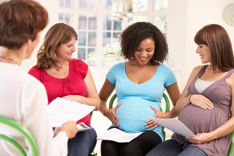 Women who are pregnant talking together.