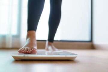 Woman weighing herself.