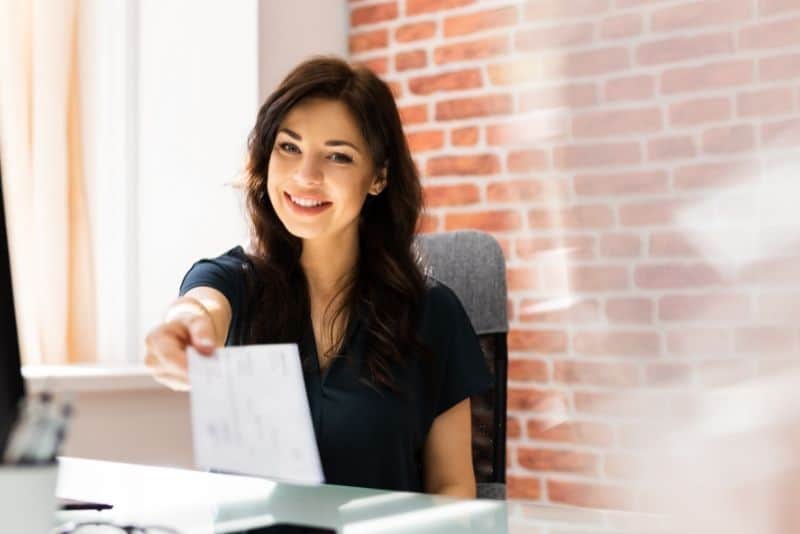 Woman giving a paycheck to someone.