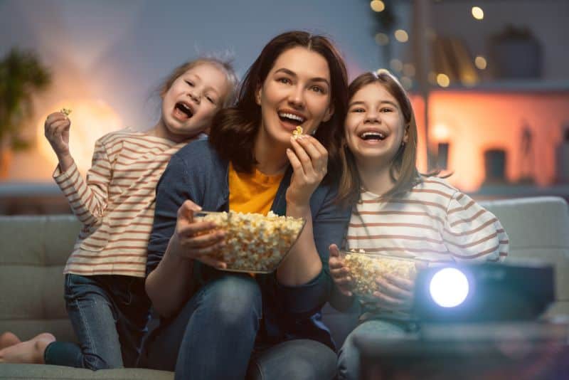 Mother and daughters watching movies.