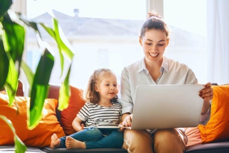 Mom proofreading a document on the computer with a child nearby.