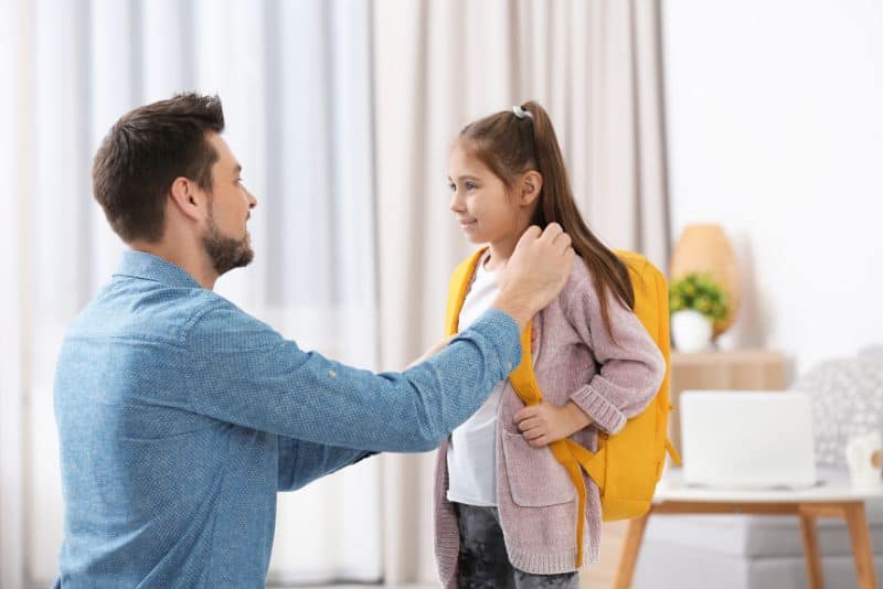 Father helping child get ready for school.