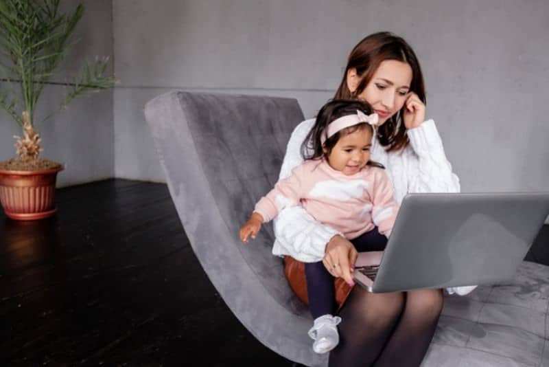 Mom blogging with her child on her lap.