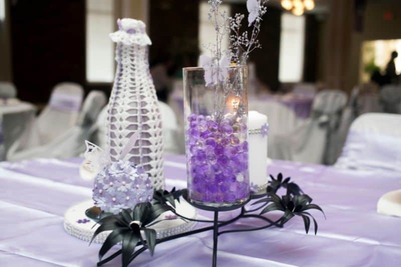 simple diy wedding table decor lavendar pebbles in glass jar with babys breath and crochet covered vase