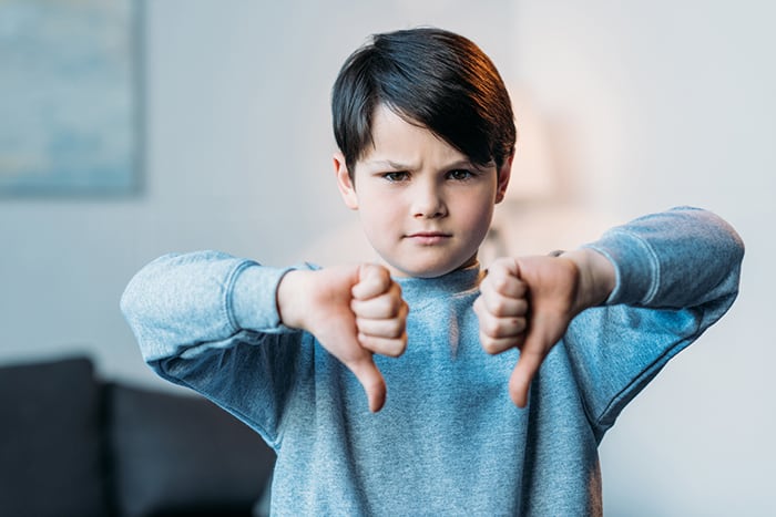 strong-willed child boy thumbs down